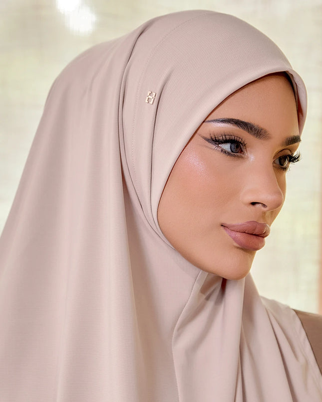 Woman wearing a beige hijab with a soft, blurred background